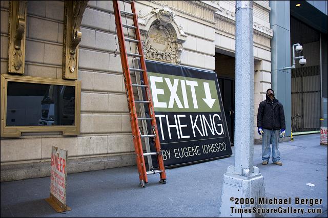 Worker looking up preparing to raise the Exit The King sign on The Barrymore Theatre in Times Square. 2009.