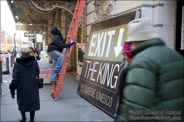 Worker climbing ladder to marquee to raise the Exit The King sign on The Barrymore Theattre in Times Square. 2009.